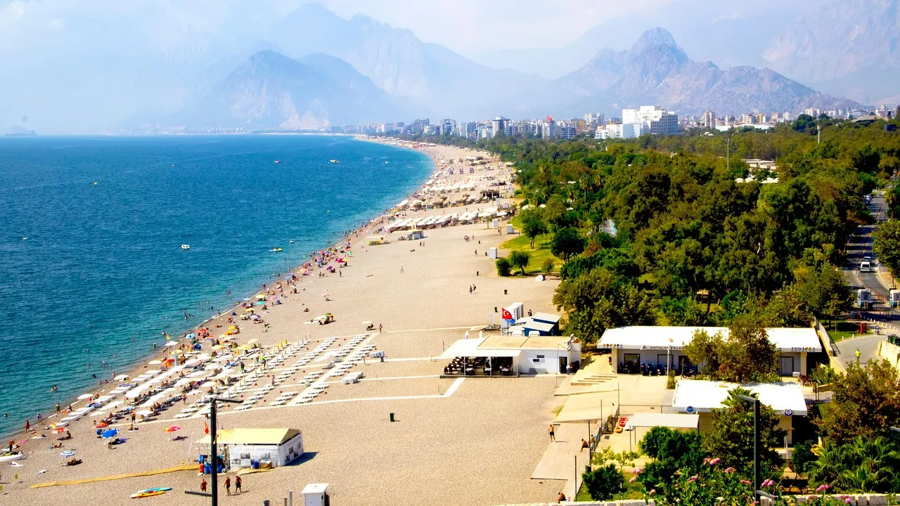 The long curve of Konyaaltı Beach in Antalya, with turquoise sea and mountains in the distance