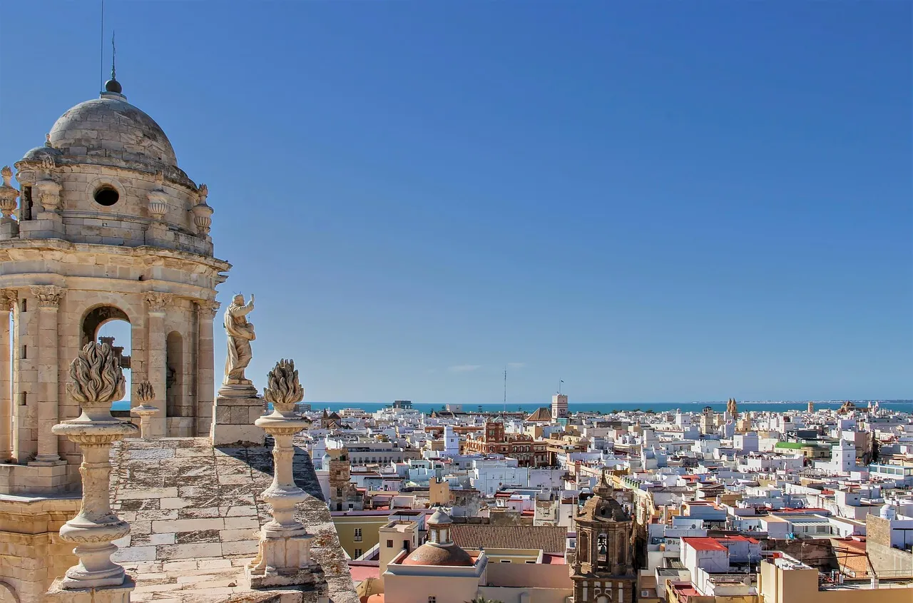 View over the white rooftops and church towers of Cádiz to the Atlantic, from beside a cathedral bell tower