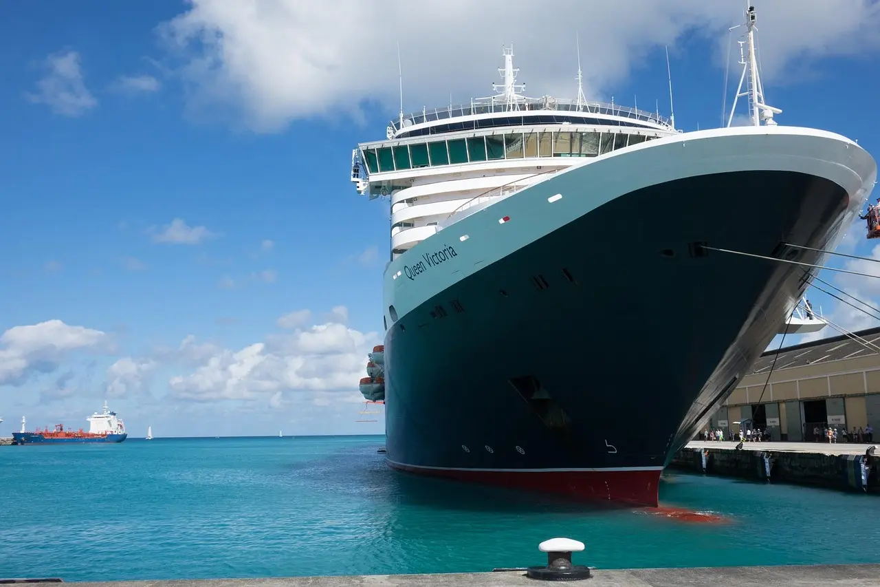 A large cruise ship docked at Bridgetown in Barbados, with turquoise water and blue sky
