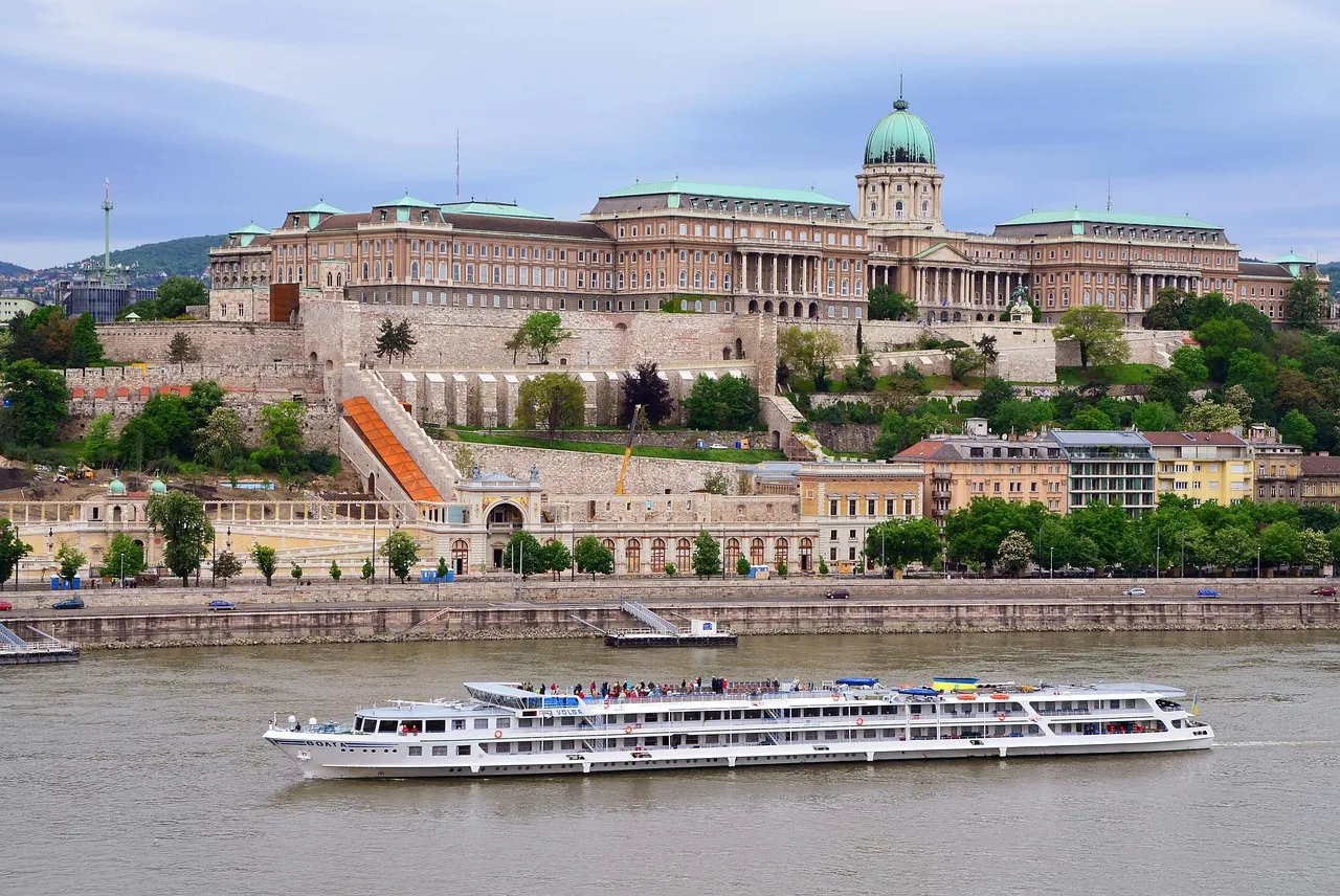 A long river cruise boat on the Danube in Budapest, below Buda Castle on the hill