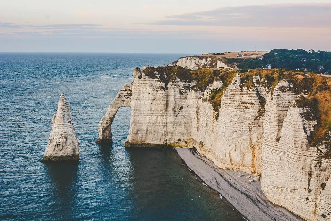 The chalk arch and needle rock at Étretat above a pebble beach