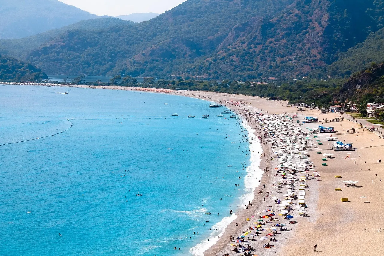The long beach at Ölüdeniz near Fethiye, curving below green mountains