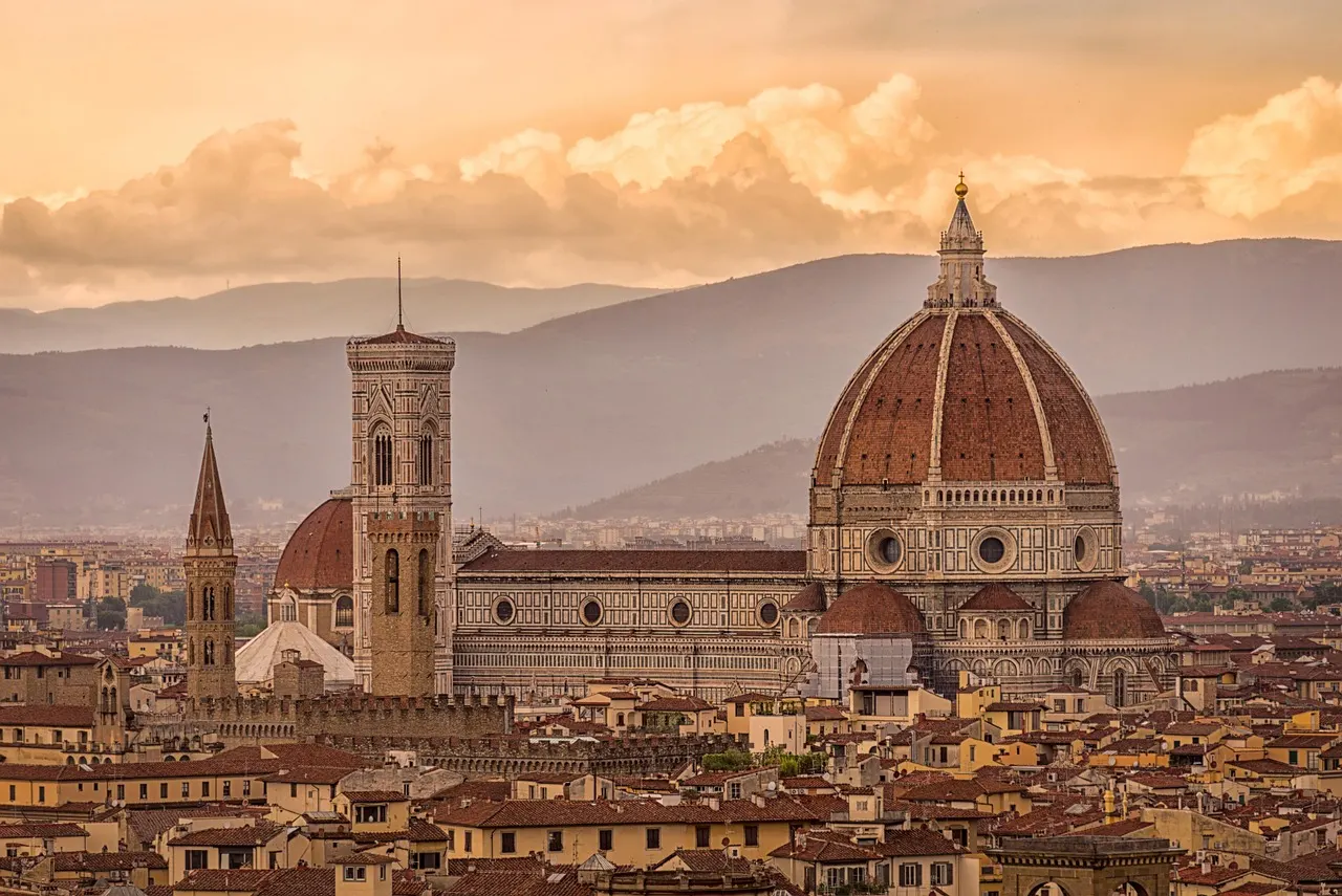 Florence Cathedral's red-tiled dome and Giotto's bell tower rising above the city's rooftops, with hills behind