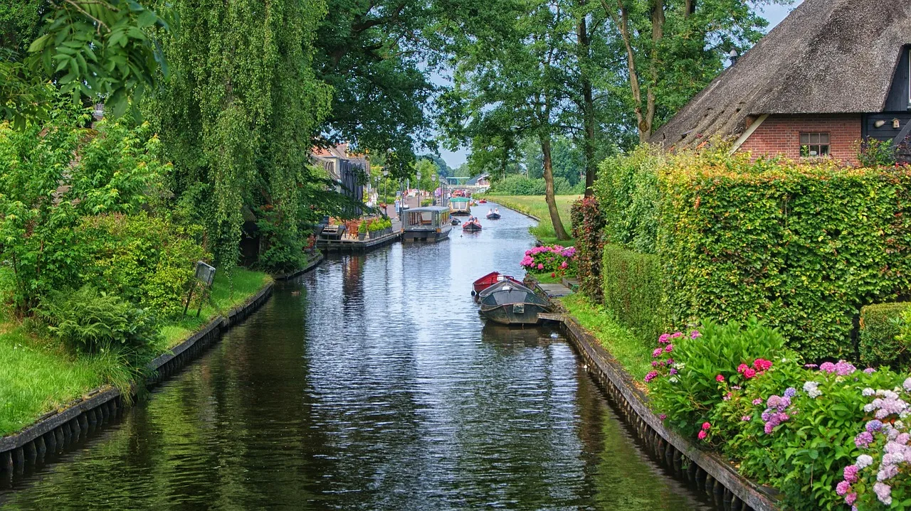 A quiet canal past thatched houses and gardens in Giethoorn