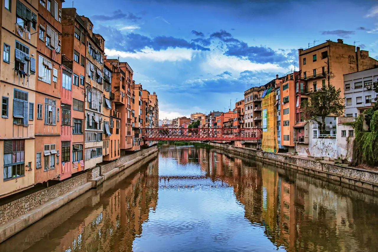Colourful houses along the Onyar river in Girona, reflected in the water