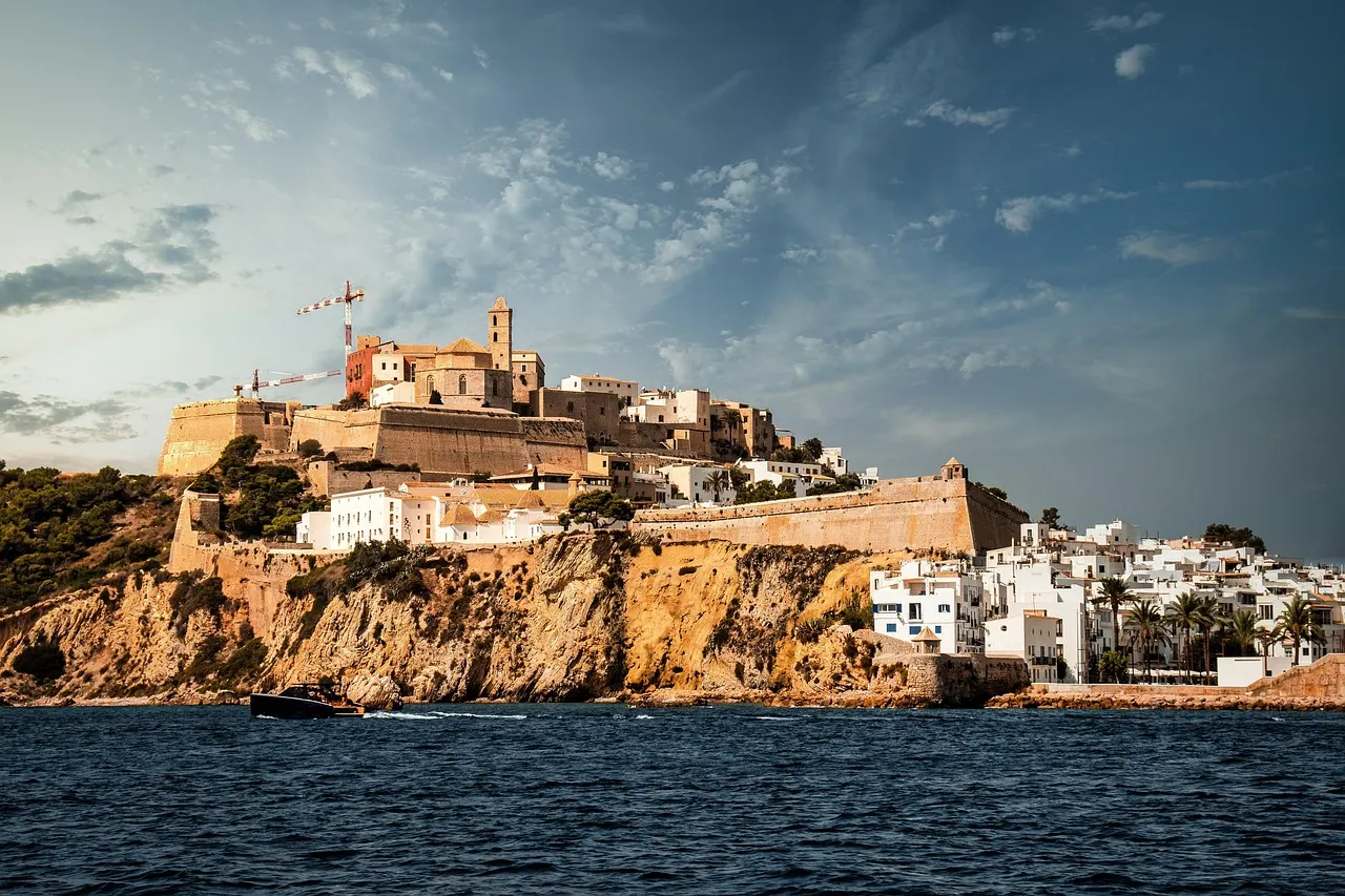 The walls and houses of Dalt Vila, Ibiza's old town, rising above the sea under a blue sky