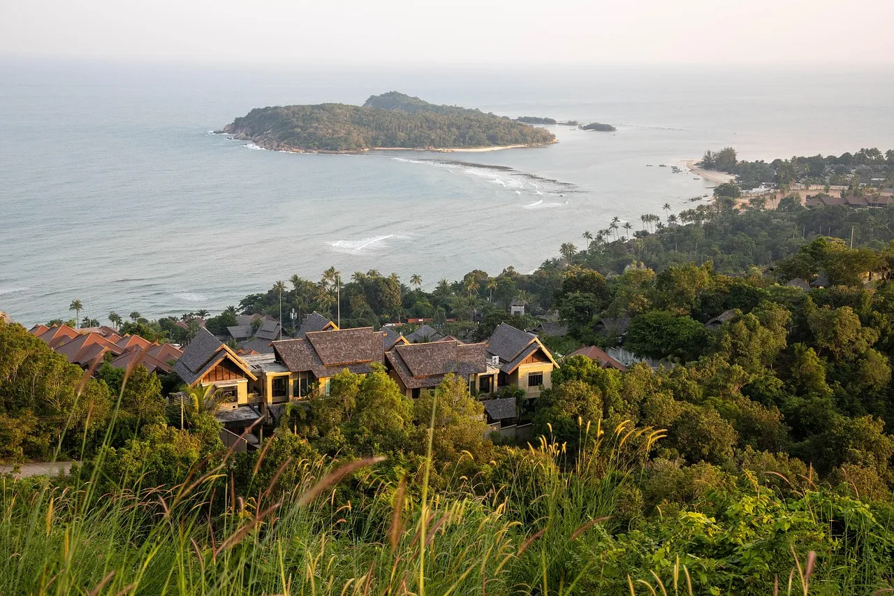 A sea view on Koh Samui, with hotel roofs among green trees and small islands off the coast
