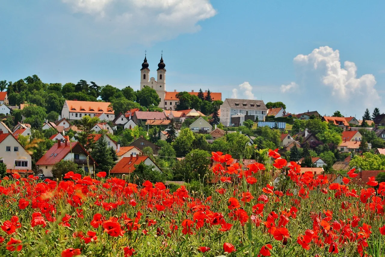 Tihany's twin-towered abbey above red poppies by Lake Balaton