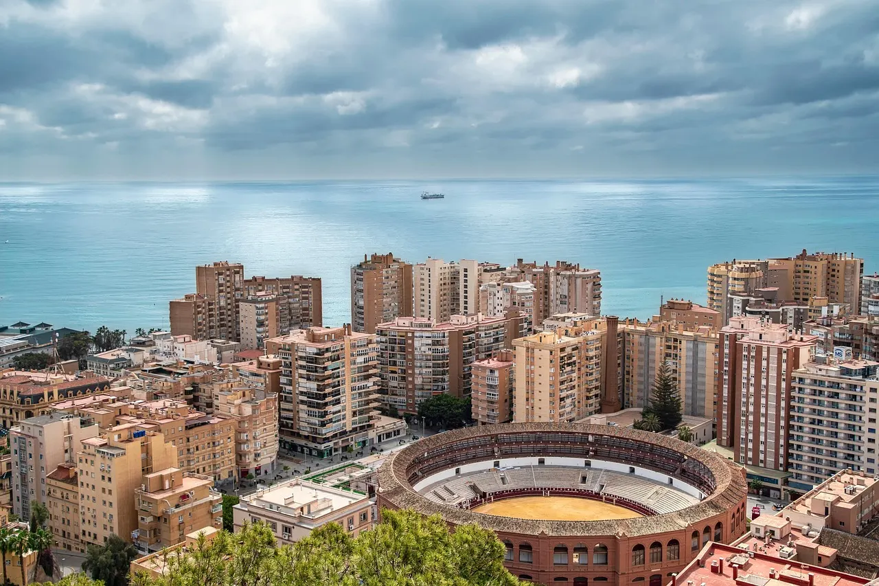 Malaga's apartment blocks, round bullring and harbour along the sunny Mediterranean coast