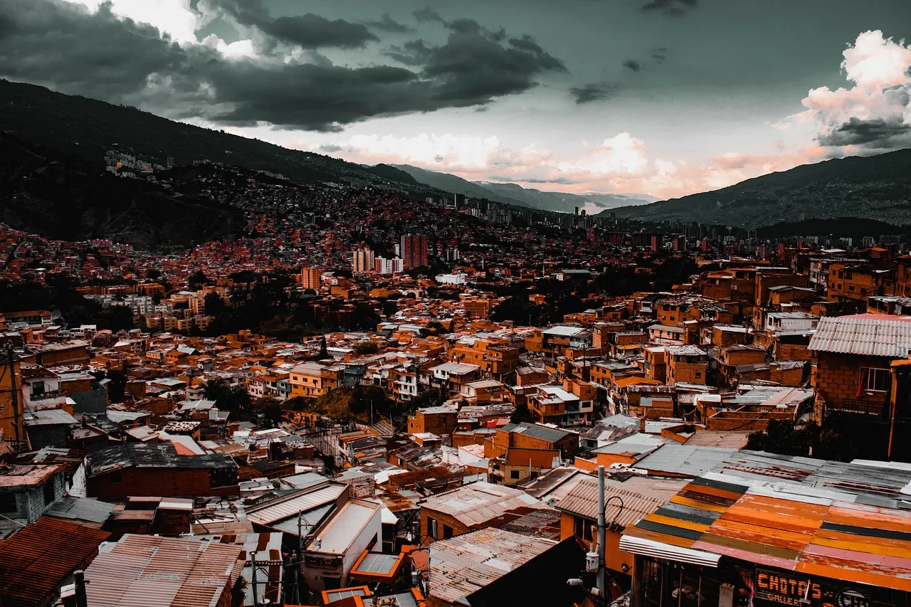 Medellín's hillside neighbourhoods climbing the green valley under a stormy sky