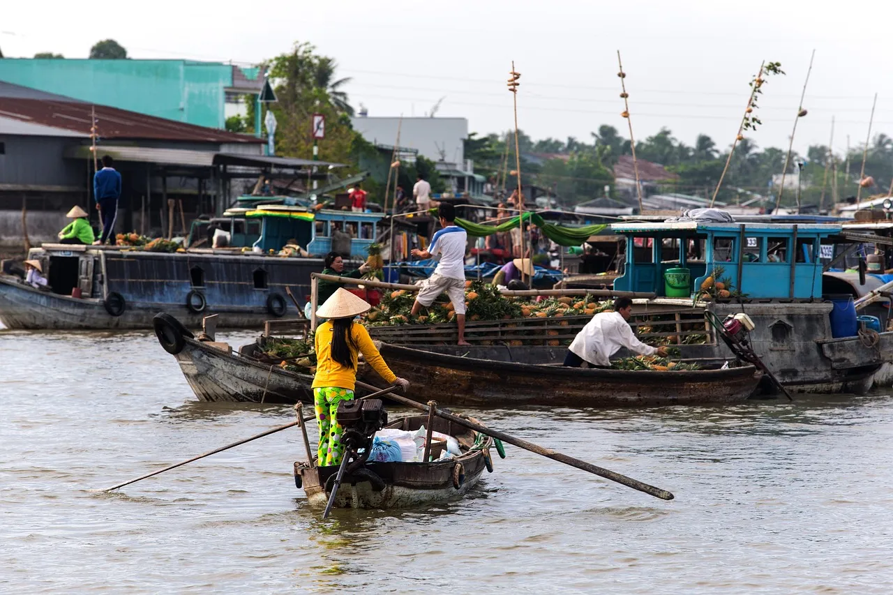 Small wooden boats laden with fruit and vegetables at a floating market on the Mekong Delta in Vietnam