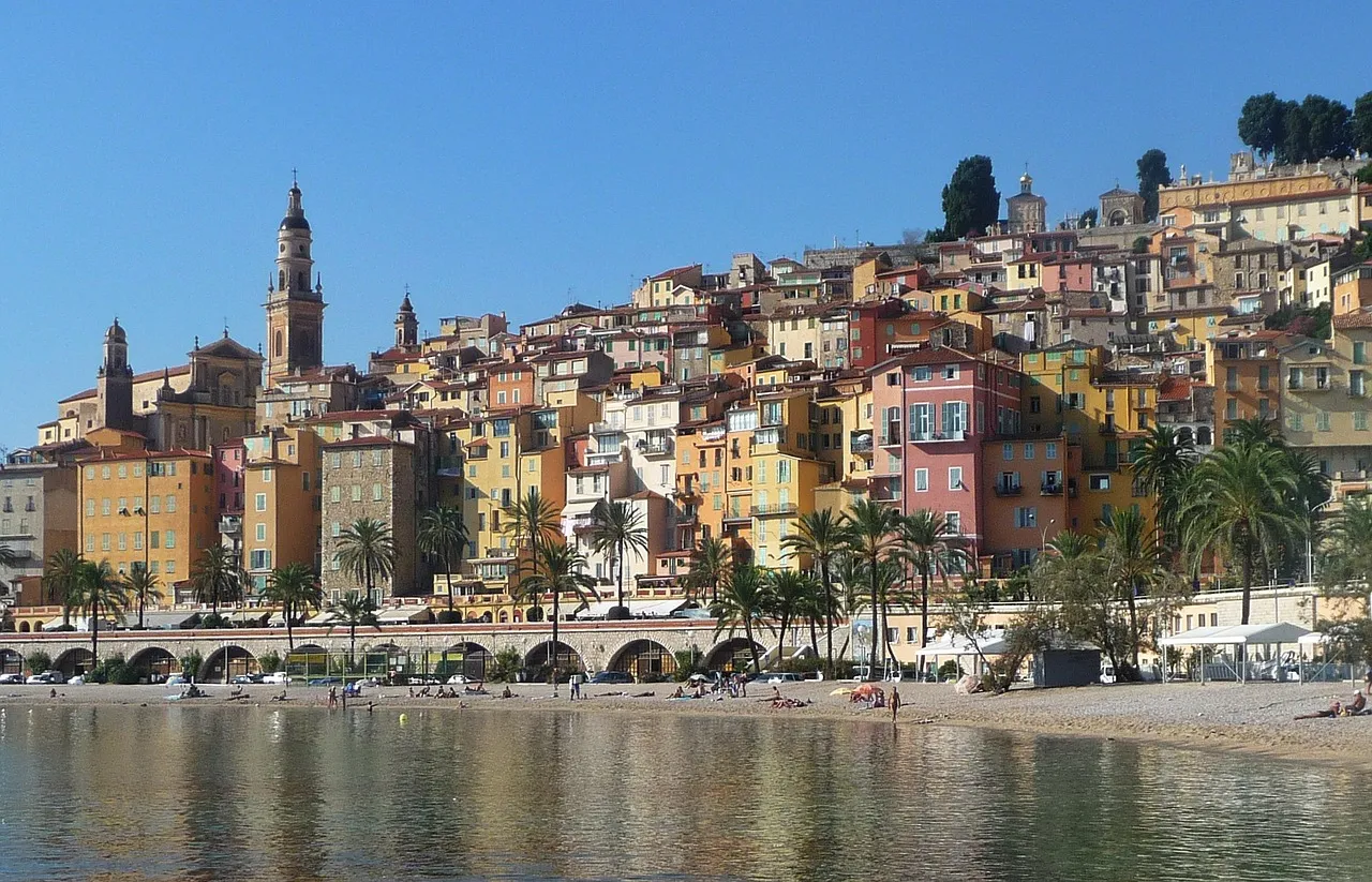 Menton's pastel old town and church tower above the beach