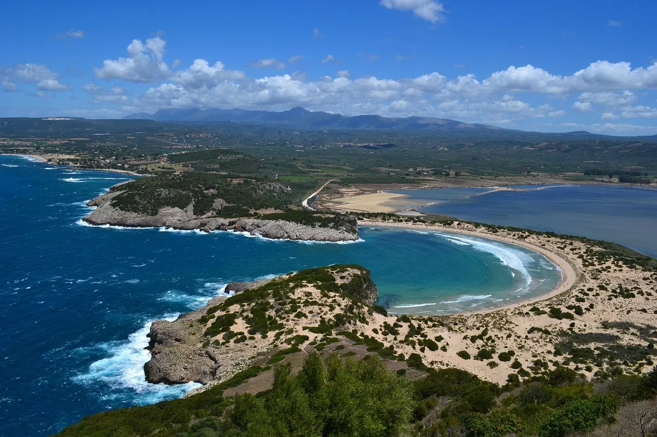 Voidokilia beach, a perfect sandy horseshoe bay with turquoise water, seen from the hillside above near Pylos in Messinia