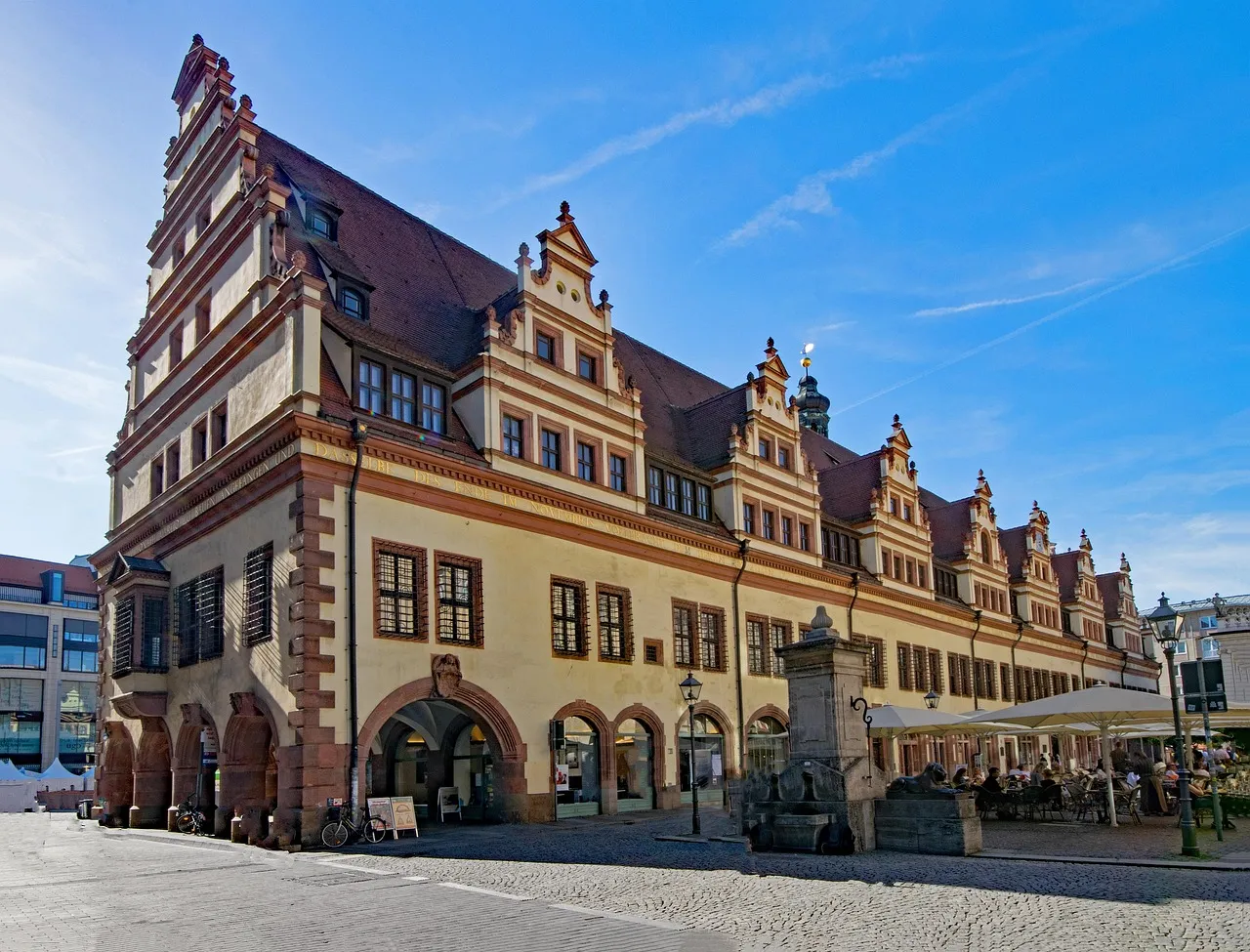 The long Renaissance Old Town Hall on Leipzig's Market Square, with its arcades, gables and tower under a blue sky