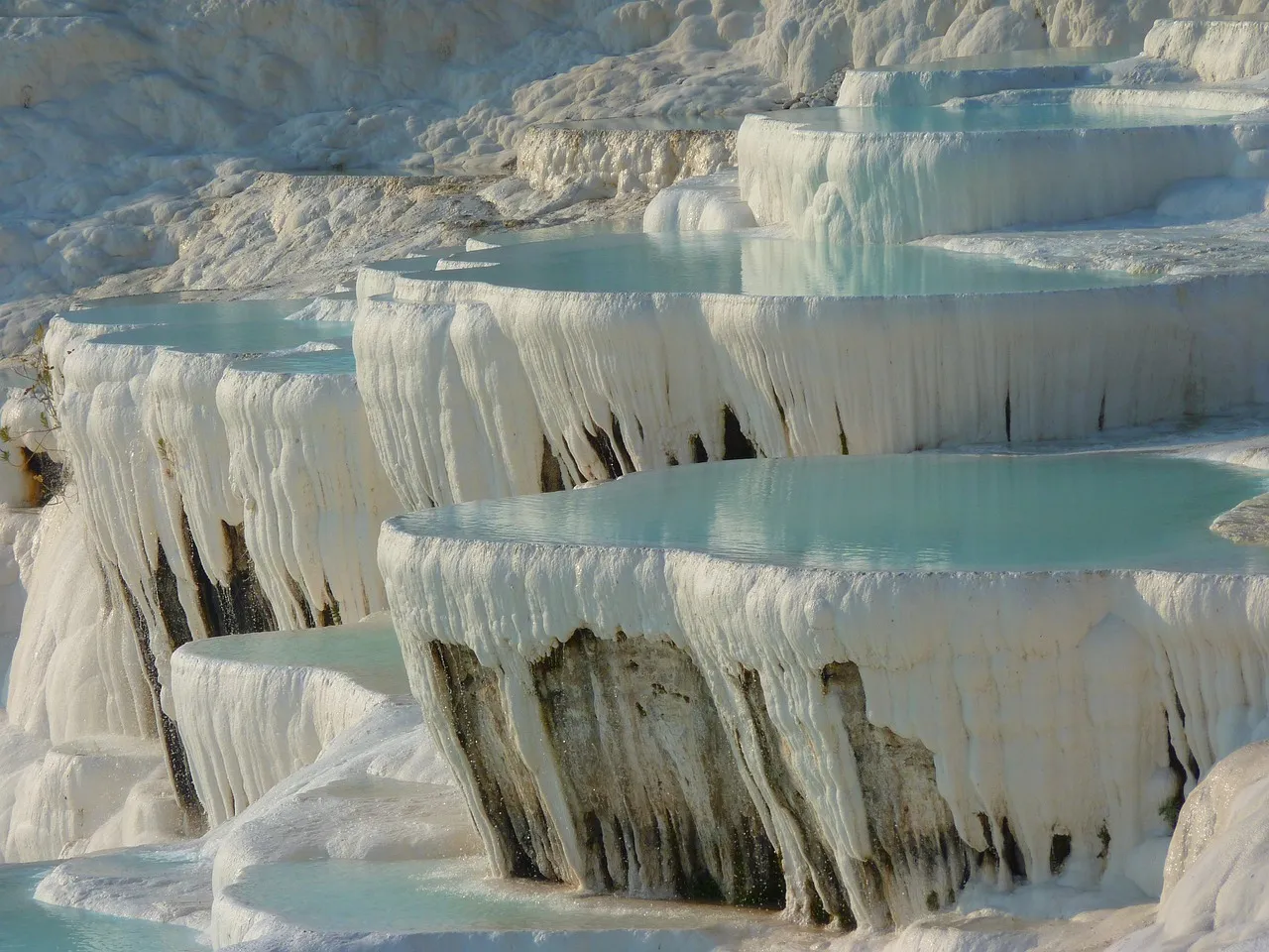 Turquoise pools of warm water on the bright white travertine terraces of Pamukkale
