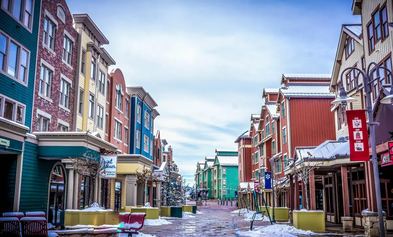 Colourful wooden-fronted buildings lining a snowy pedestrian street in Park City