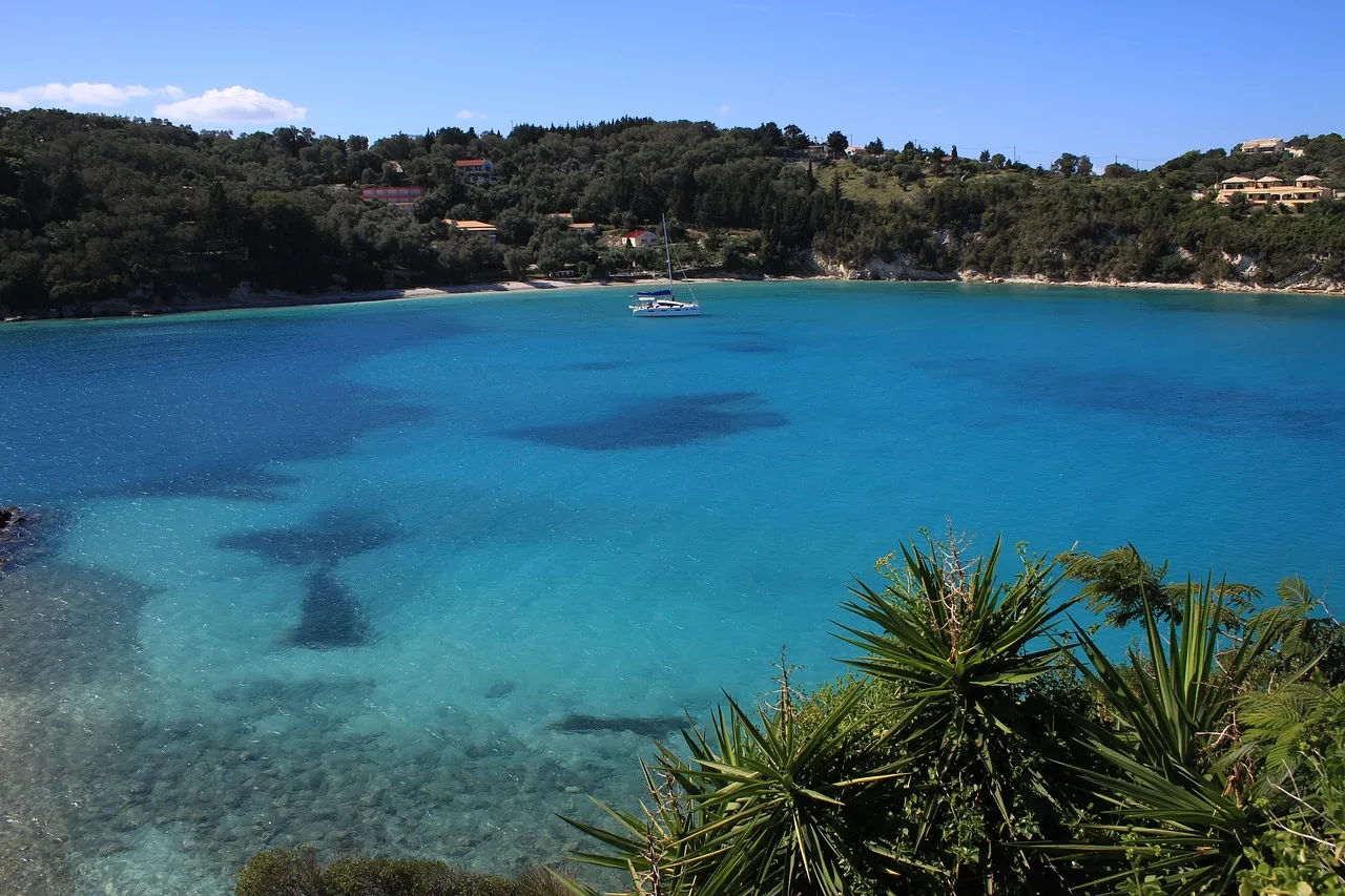The calm turquoise bay at Lakka on Paxos, with olive trees on the shore