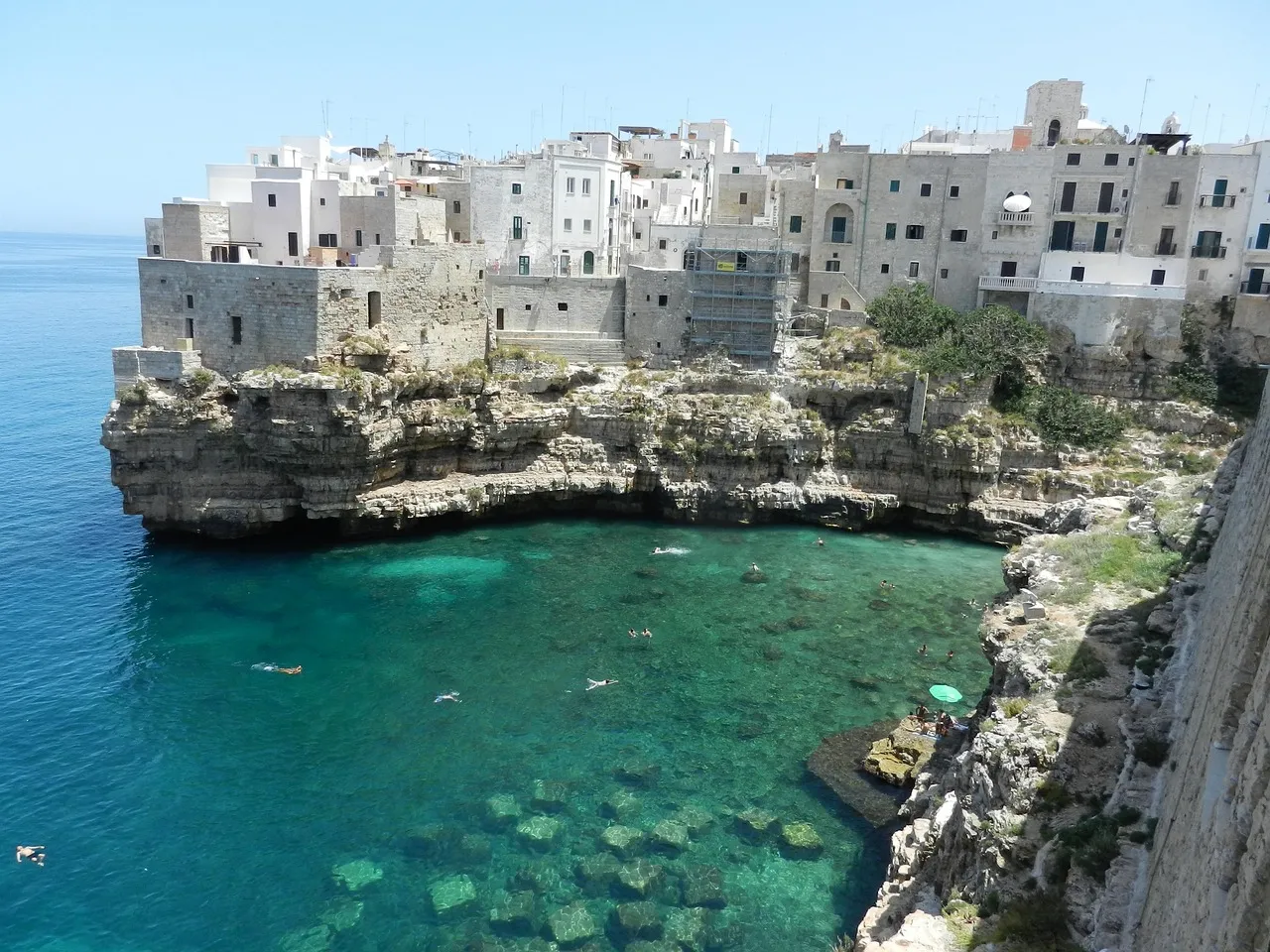 Whitewashed houses of Polignano a Mare on cliffs above turquoise water