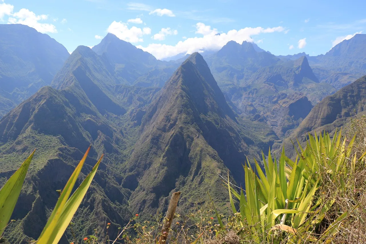 Steep green mountain peaks and ridges of the Cirque de Mafate on Réunion island under a blue sky