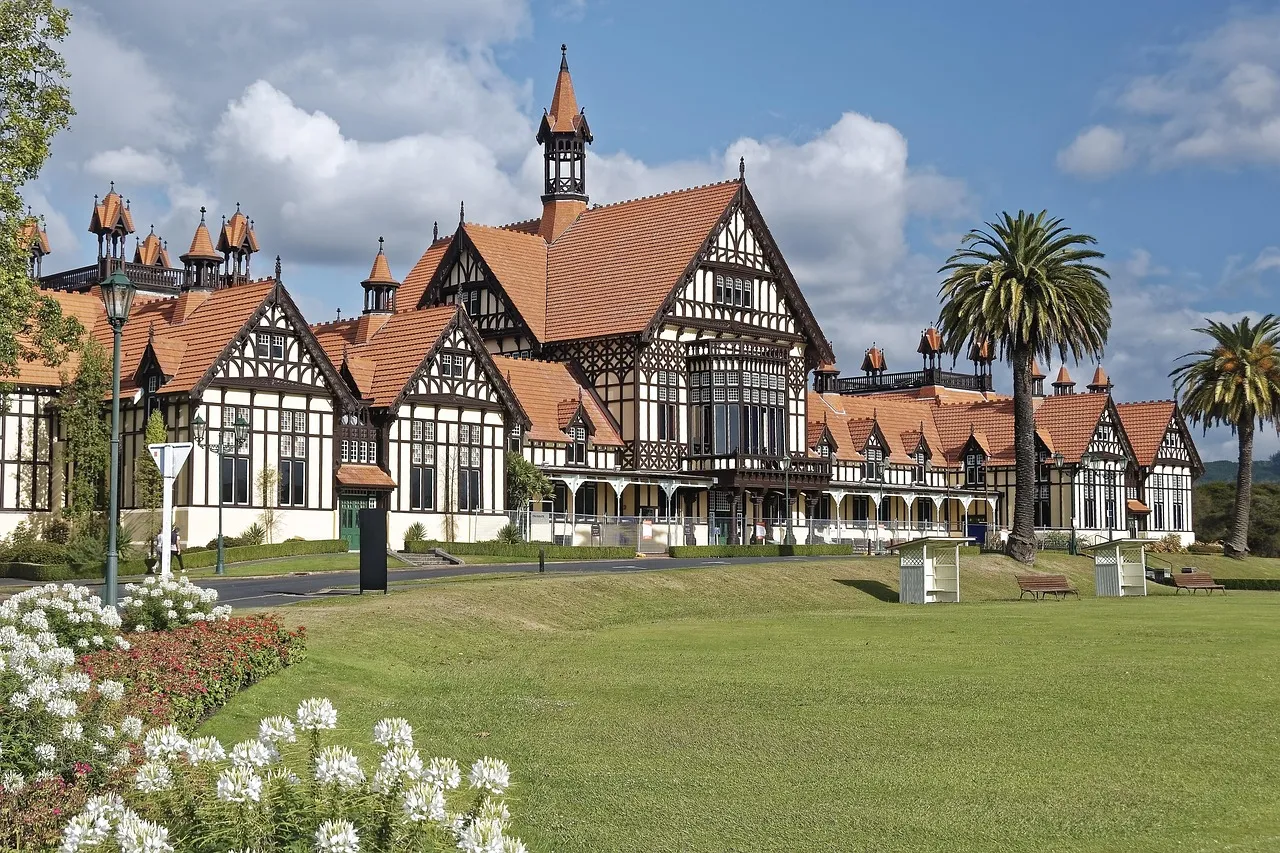The Tudor-style former bath house in Rotorua, now the town's museum, behind a green lawn and palm trees