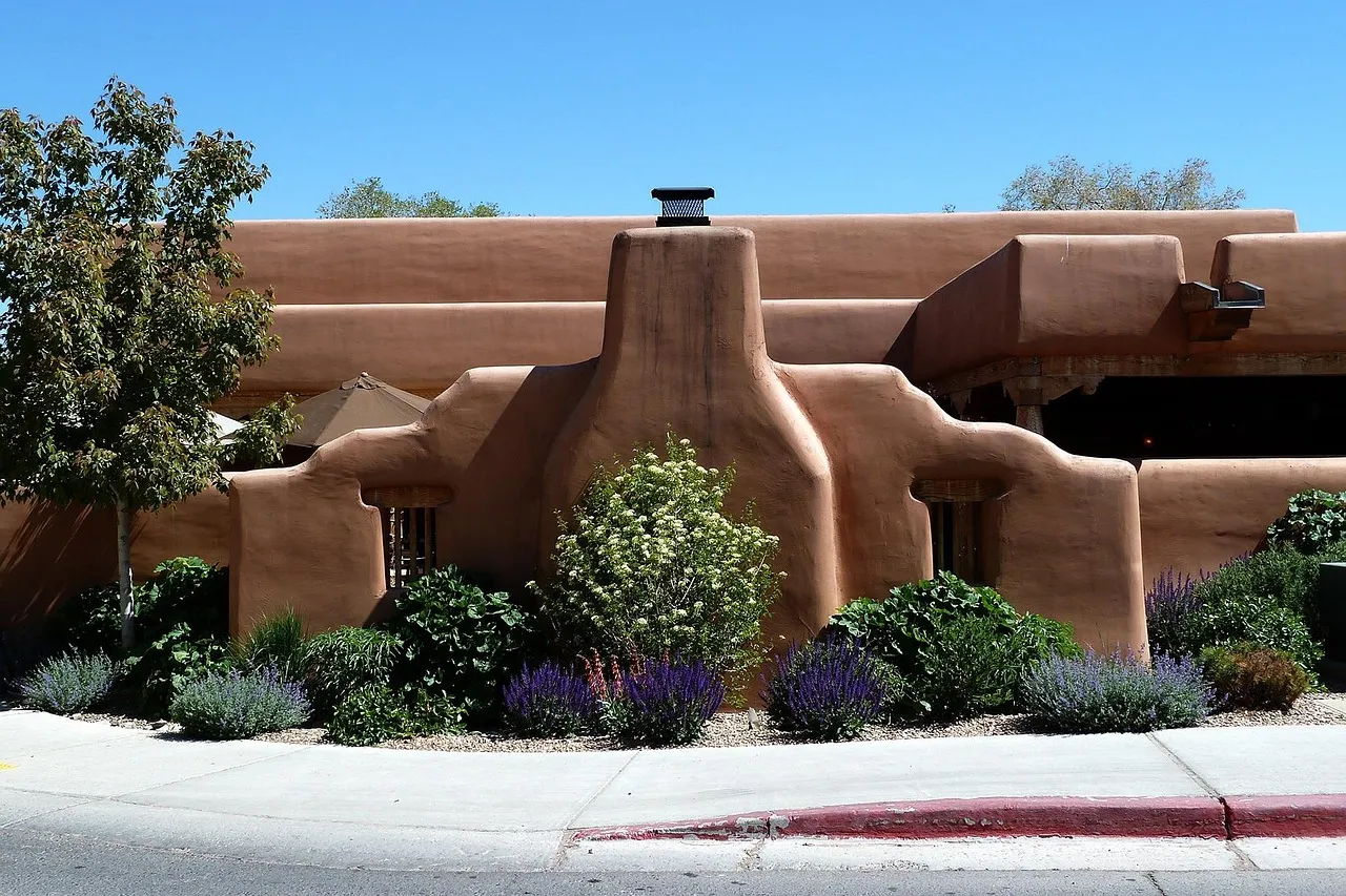 A traditional adobe building with lavender in front, in Santa Fe