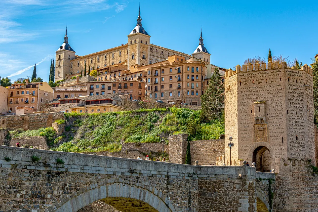 The Alcázar of Toledo above the Alcántara bridge and old city walls