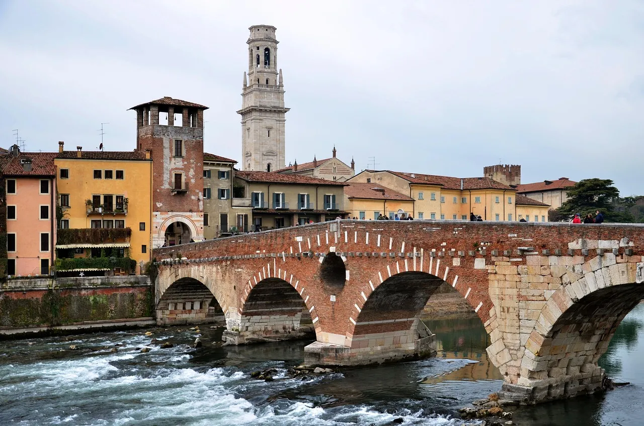 The Ponte Pietra bridge over the Adige river in Verona, with a bell tower behind