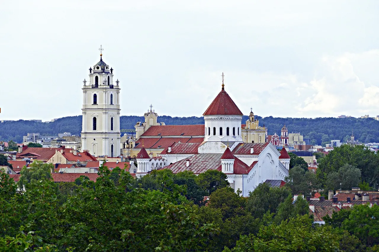 Church towers and red roofs of Vilnius old town among green trees