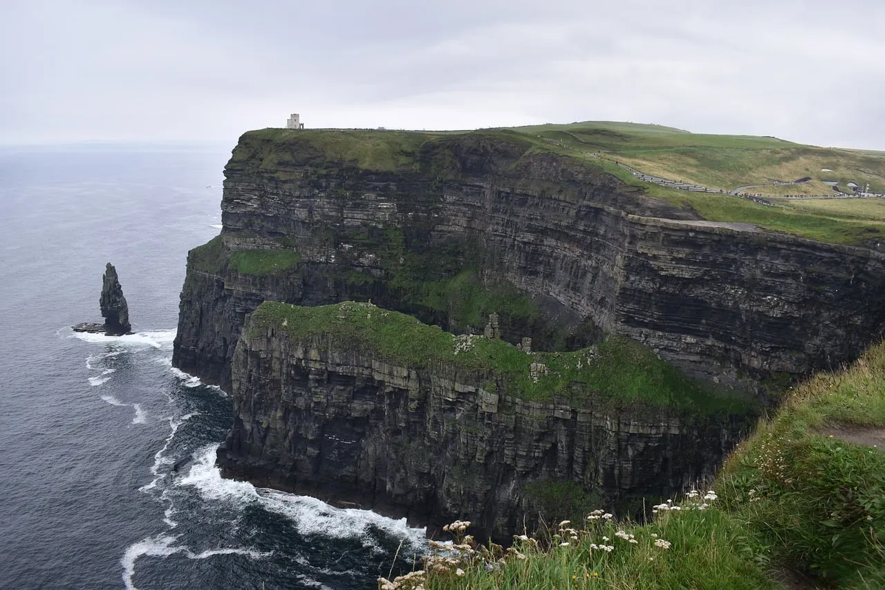The Cliffs of Moher in County Clare dropping into the Atlantic, with green clifftops and a sea stack