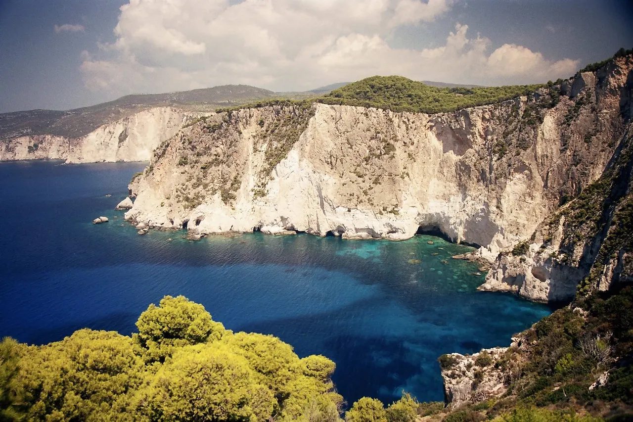 White limestone cliffs dropping into deep turquoise water on the coast of Zakynthos