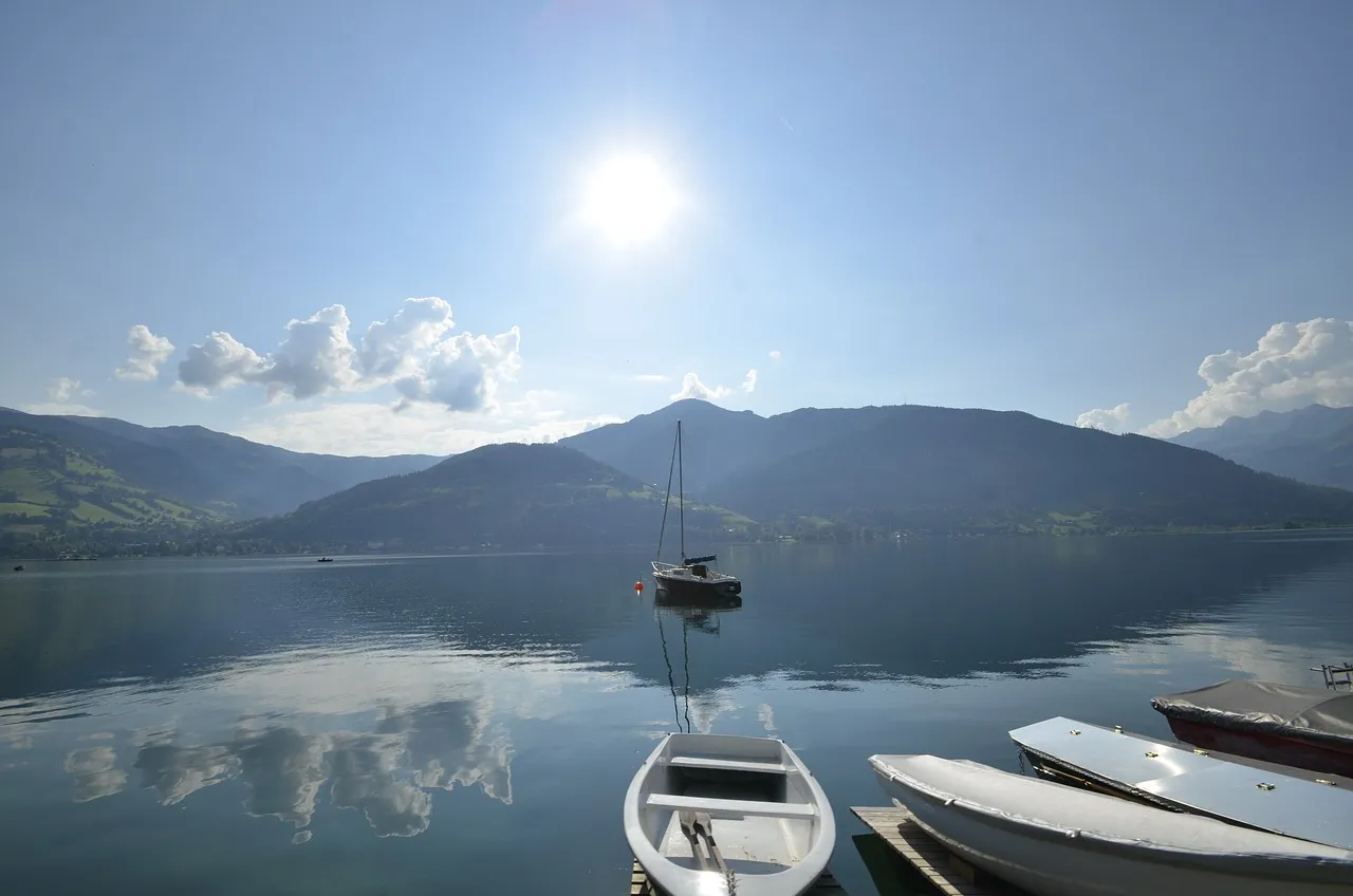 Boats on a calm Lake Zell with mountains behind